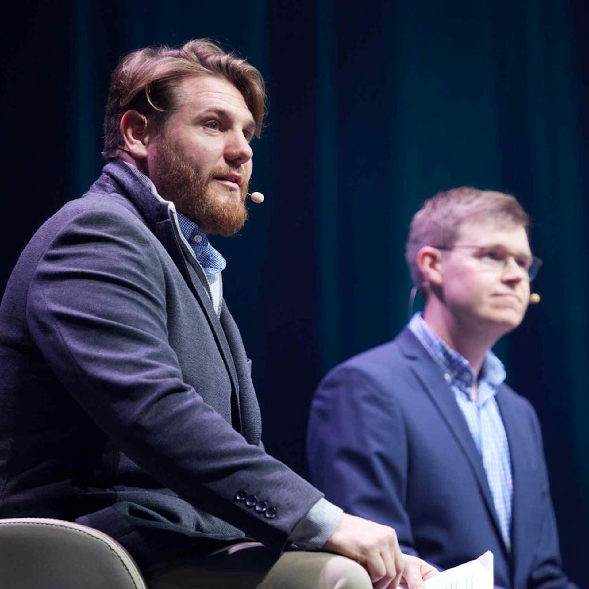 An image of Thomas Mayfield on stage during a panel.