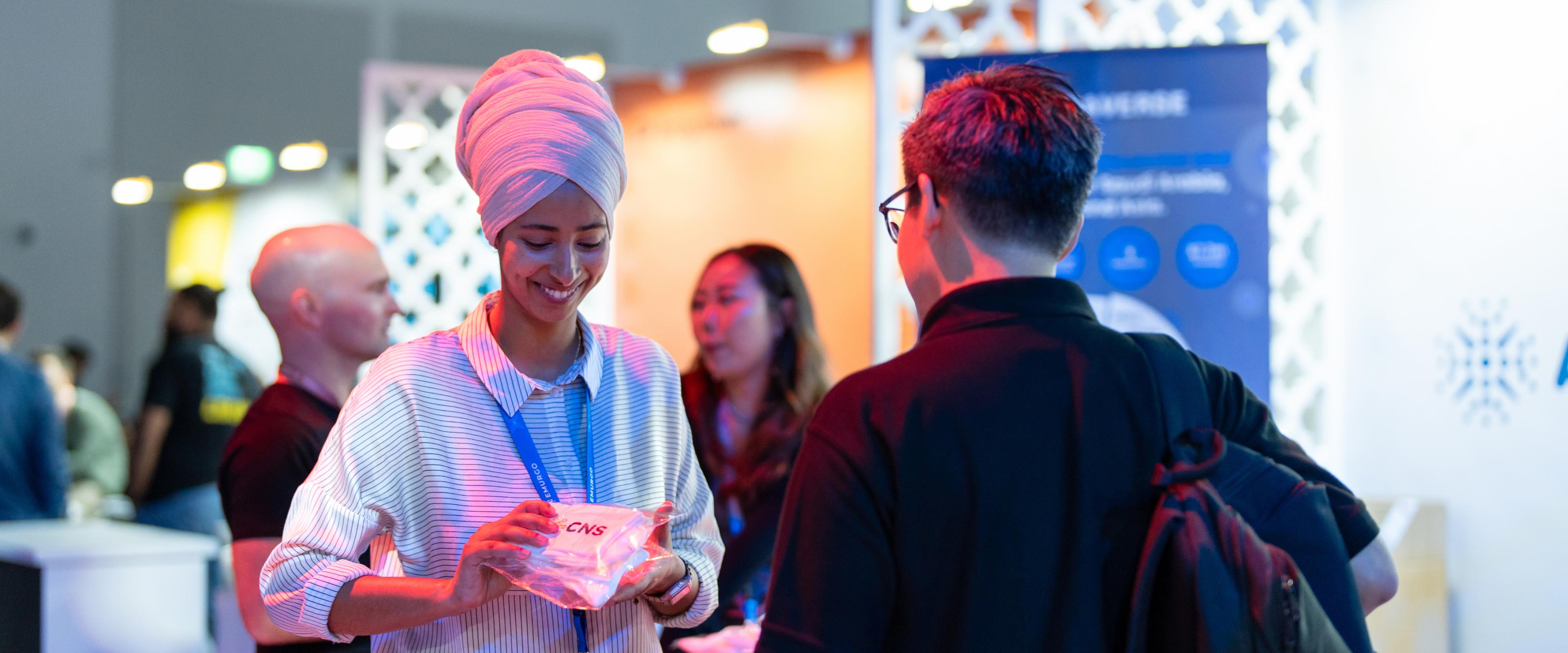 Two people interacting at the Cardano Foundation booth.